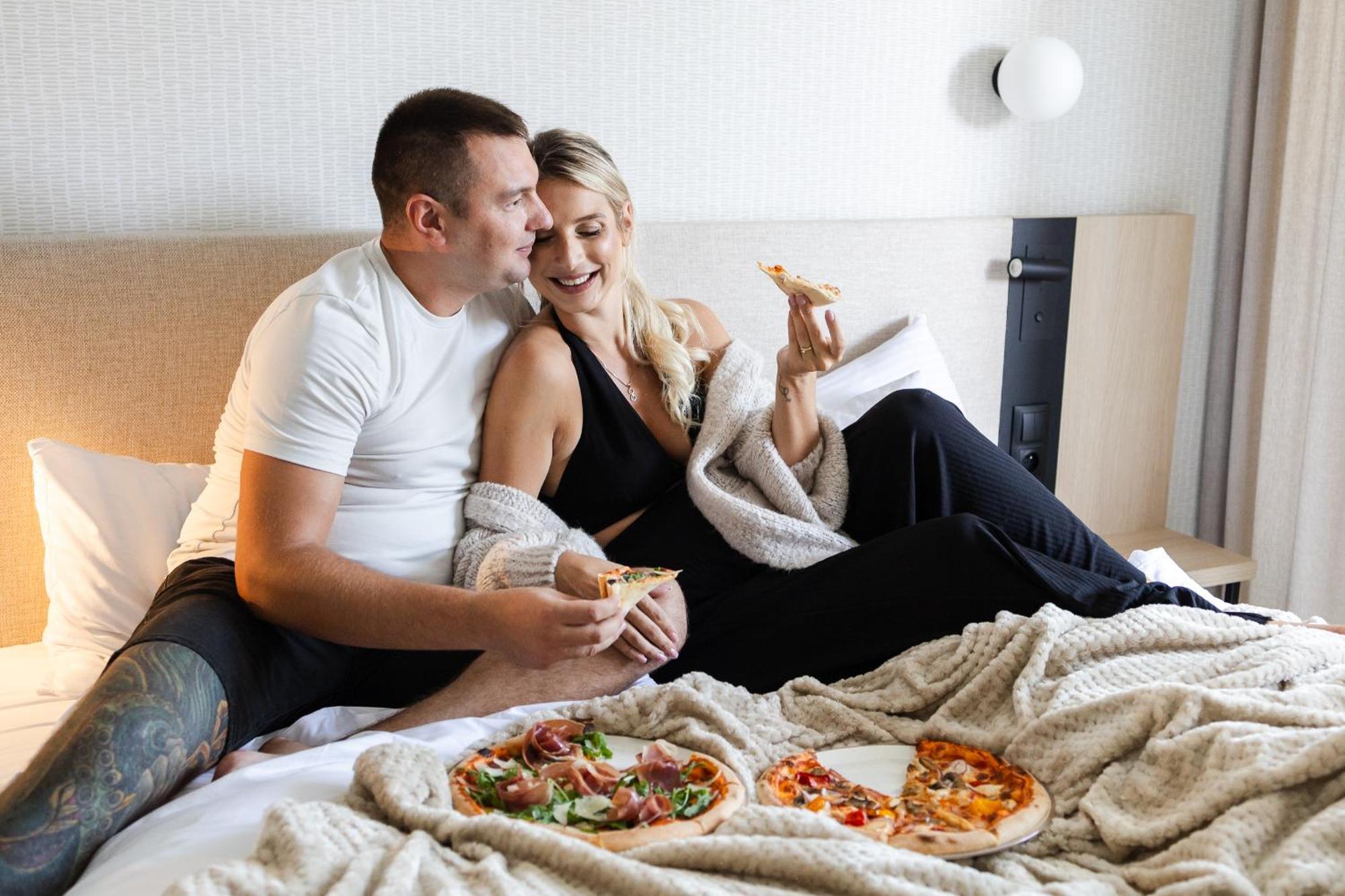 Hotel Linea Mare Pobierowo Exterior photo A couple eating pizza in bed